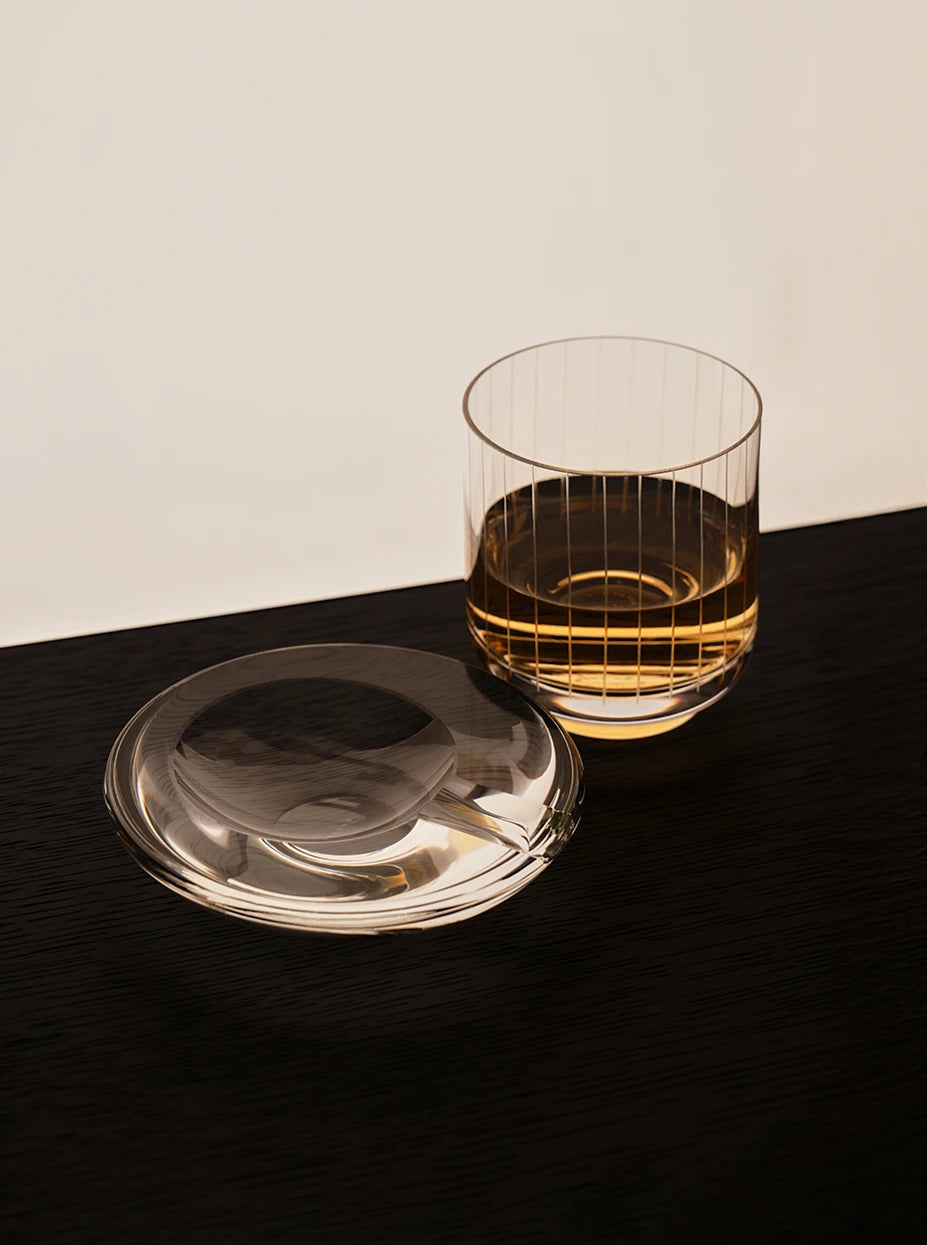 Minimal bar set layout shot of WATERDROP L large crystal ashtray matched with vertical striped whisky tumbler on dark wood table