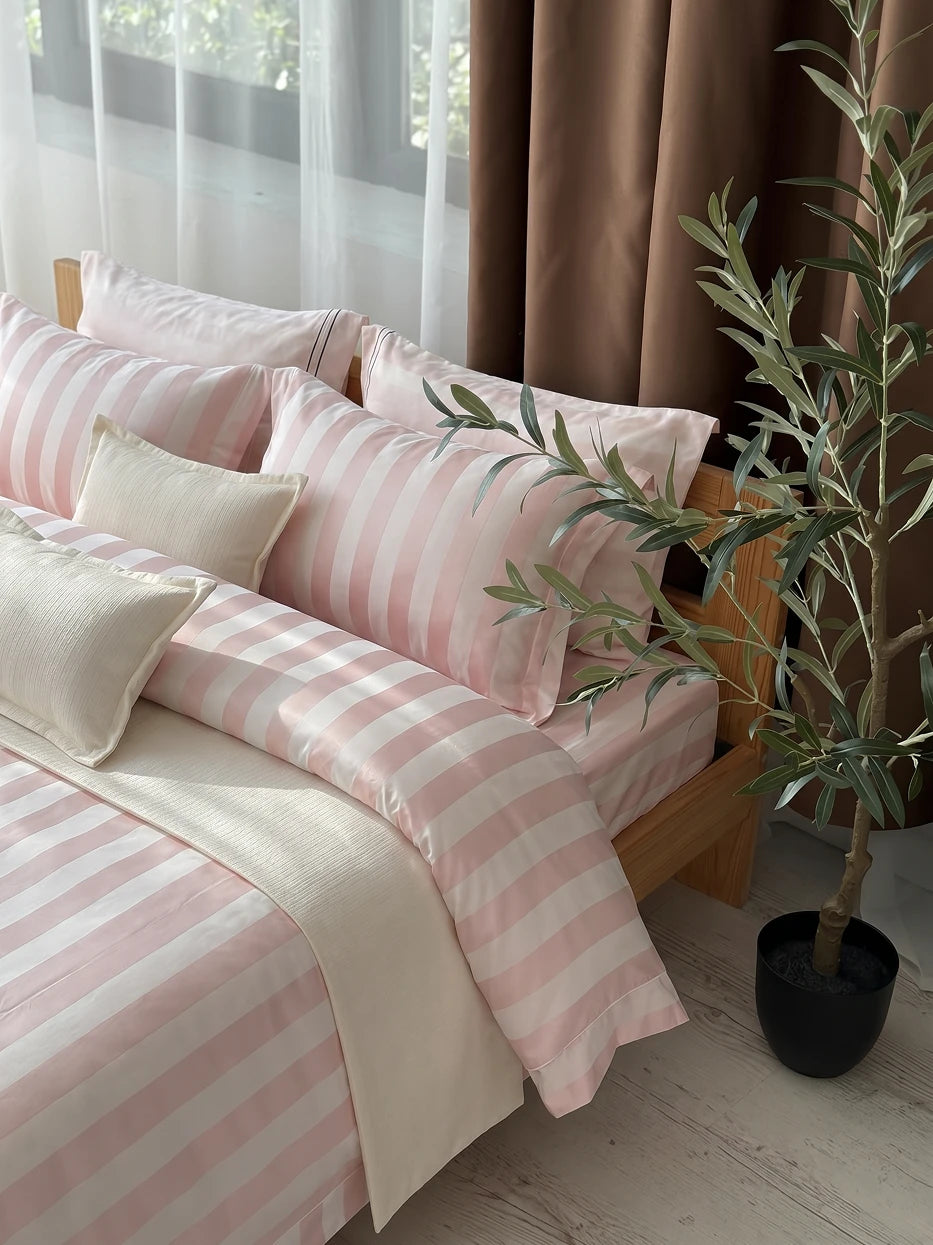 Close-up furnishing shot of full XUGUANG pink bedding set on solid wood bed showing wide yarn-dyed jacquard fabric & delicate piped edge