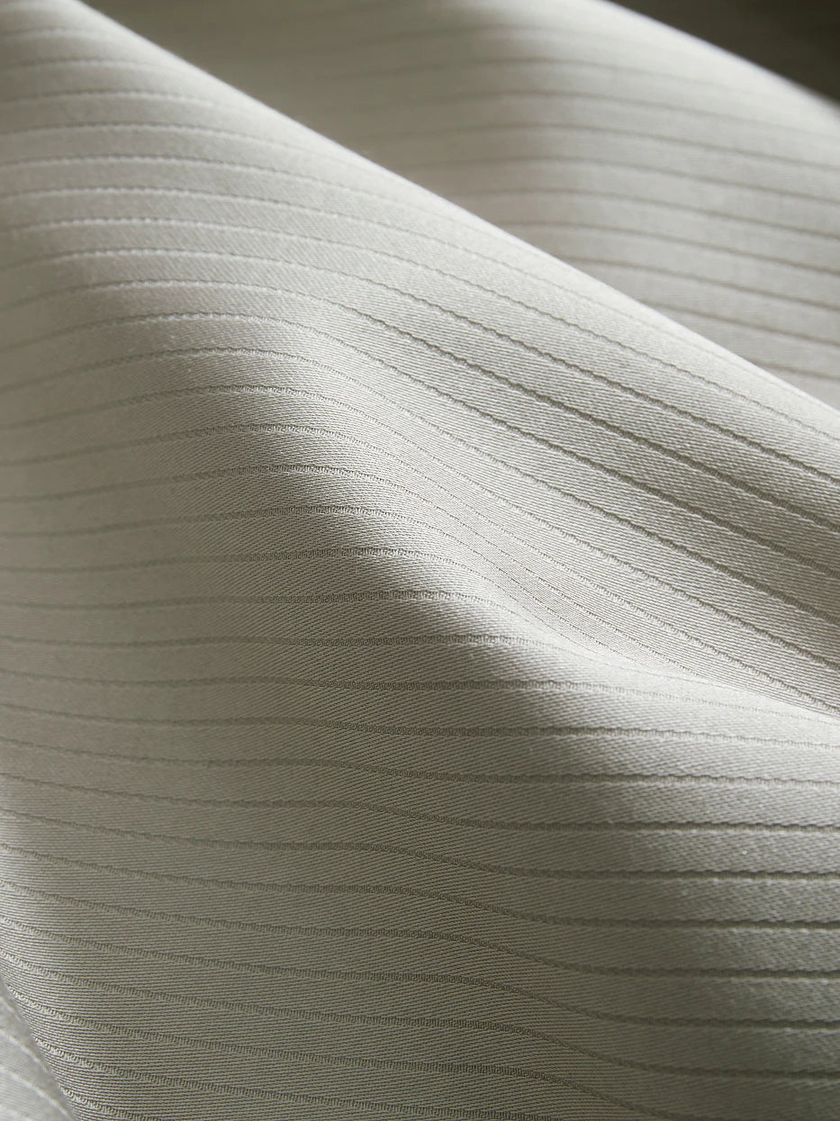 Soft light close-up shot of YALIAN cotton fabric, showing even delicate vertical mini jacquard stripes, tight high-density weaving