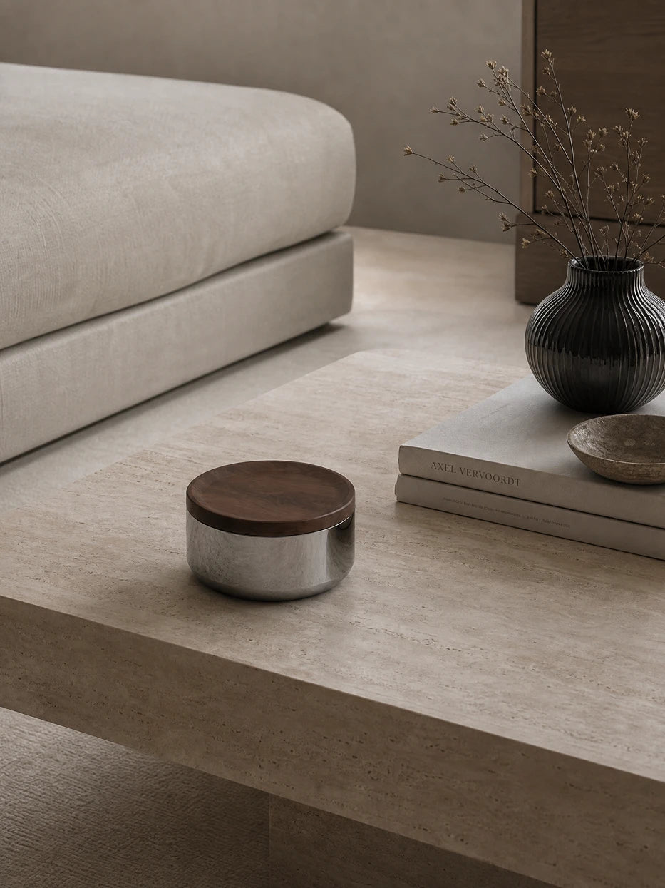 Wabi-sabi home furnishing shot of YINGMU L storage can on natural travertine round coffee table, matched with art books and vintage vase